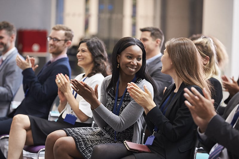 Diverse group of medical professionals clapping at a medical conference