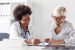 Medizinisches Fachpersonal im Gespräch mit einer älteren Patientin über medizinisches Cannabis